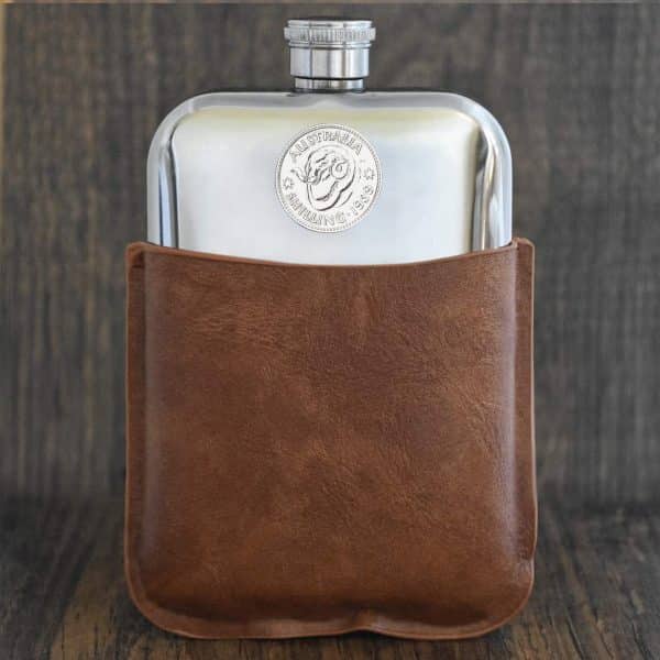 1939 Australian shilling set into the front of a polished hip flask, in a brown leather sleeve