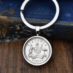 1942 Australian sixpence set in a polished silver bezel keyring, kangaroo and emu coat of arms, on wood