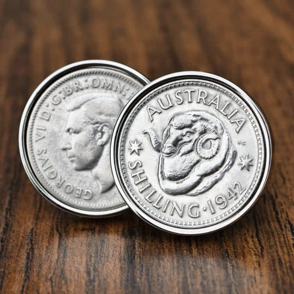 Pair of 1942 Australian shilling cufflinks in polished silver bezels, ram's head and George VI sides, on dark wood