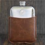 Polished pewter hip flask in a tan brown leather sleeve, 1943 Australian threepence with wheat ears set into the front