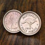 Pair of 1953 Australian half penny cufflinks in rose gold bezels, kangaroo and Queen Elizabeth II sides, on dark wood