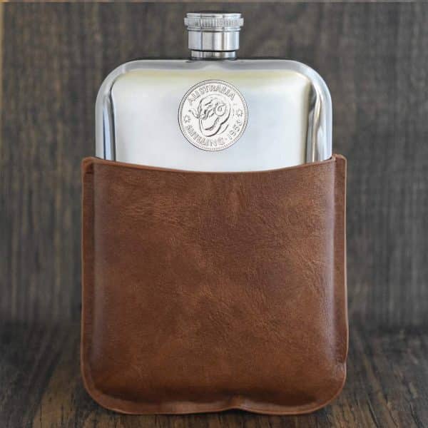1953 Australian shilling set into the front of a polished hip flask, in a brown leather sleeve