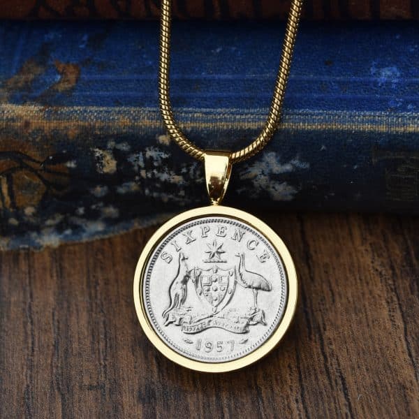 1957 Australian sixpence in a gold bezel pendant on a gold chain, kangaroo and emu coat of arms