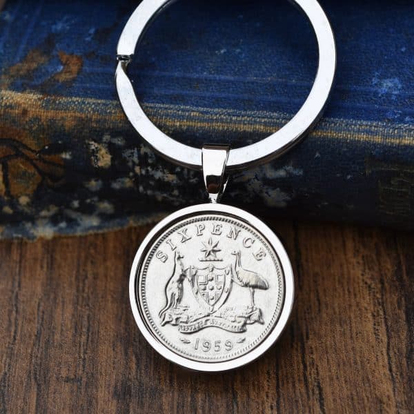 1959 Australian sixpence set in a polished silver bezel keyring, kangaroo and emu coat of arms, on wood