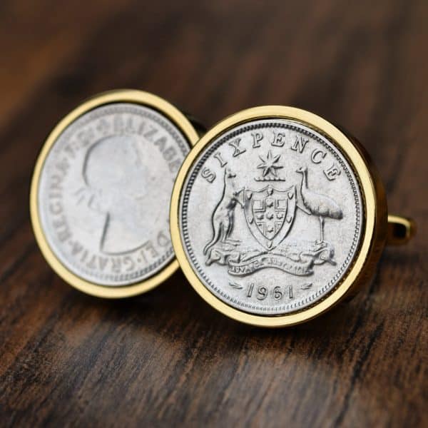1961 Australian sixpence cufflinks in gold bezels, coat of arms with kangaroo and emu, on dark wood