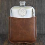 1968 Australian 20 cent coin set into the front of a polished pewter hip flask in a brown leather sleeve