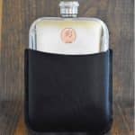 1983 Australian coin with Elizabeth II portrait set into a polished pewter hip flask in a black leather sleeve