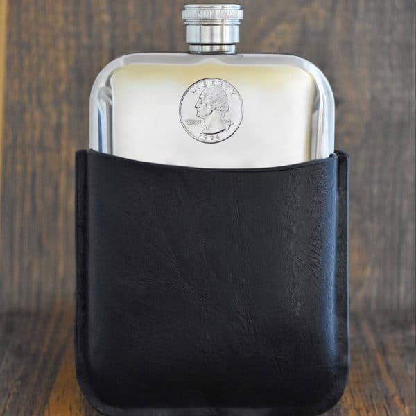 1984 United States quarter dollar with Washington portrait set into a pewter hip flask in a black leather sleeve
