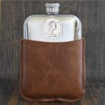 Twelve-sided 1987 Australian 50 cent coin set into a polished pewter hip flask in a brown leather sleeve
