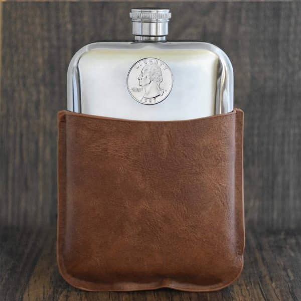 Polished pewter hip flask in a tan leather sleeve, 1987 United States quarter set into the front