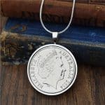 Australian coin dated 2014 in a polished silver-tone pendant setting, Elizabeth II obverse, resting on antique books