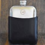 American Jefferson nickel set into the front of a polished pewter hip flask in a black leather sleeve