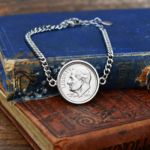 2005 US dime bracelet, silver-coloured chain and bezel, photographed on faded blue and red books