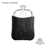 Pewter hip flask front on in a black leather sleeve, 1977 Australian coin set into the polished front