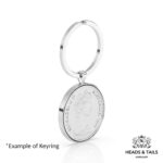 Angled view of a 1977 Australian coin in a silver bezel hanging from a split ring keyring