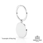 Back of a plain polished silver coin bezel hanging from a split ring keyring, angled view on a white background