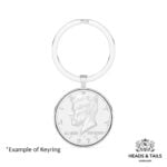 1977 US Kennedy half dollar in a polished silver bezel on a split ring keyring, shown front on against white