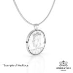 1977 US Kennedy half dollar in a polished silver bezel on a silver snake chain, angled side view on white