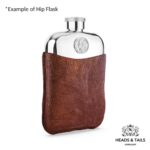 Front of a pewter hip flask with a 2000 US Jefferson nickel set in, brown leather sleeve below