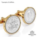 Close up of gold cufflinks set with 1957 Australian sixpences, kangaroo and emu coat of arms in detail